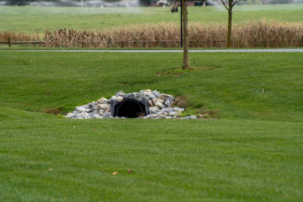 a single pipe leading underground in a park