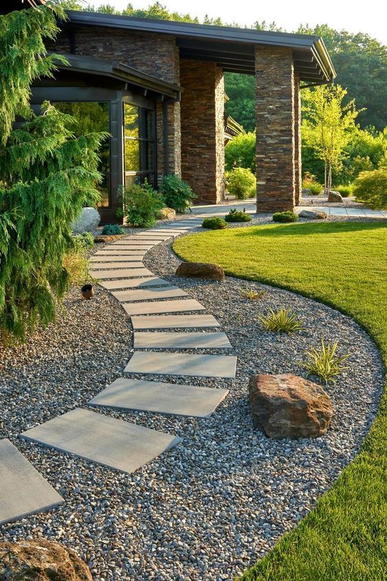a stylish modern garden with green lawn rocks moss trees and a curved gravel pathway with additional stone steps